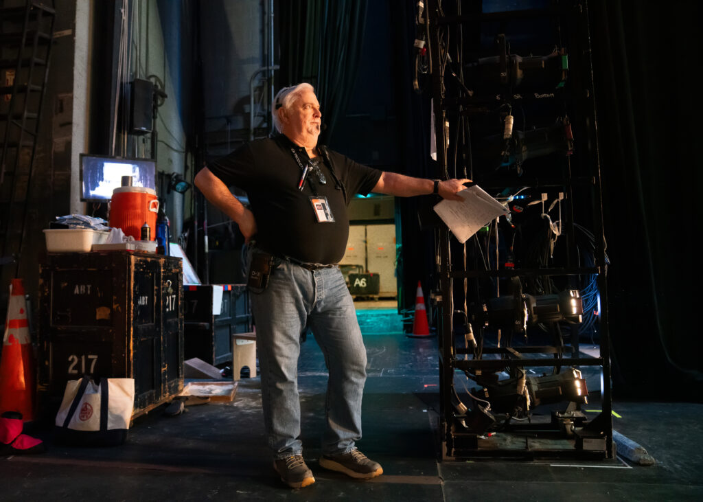 a man standing backstage watching from the wings
