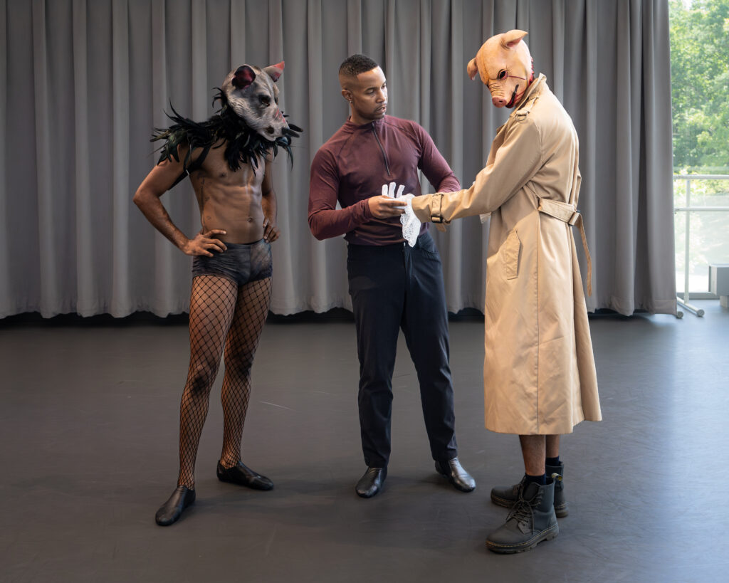 a man helping two dancers wearing animal costumes 