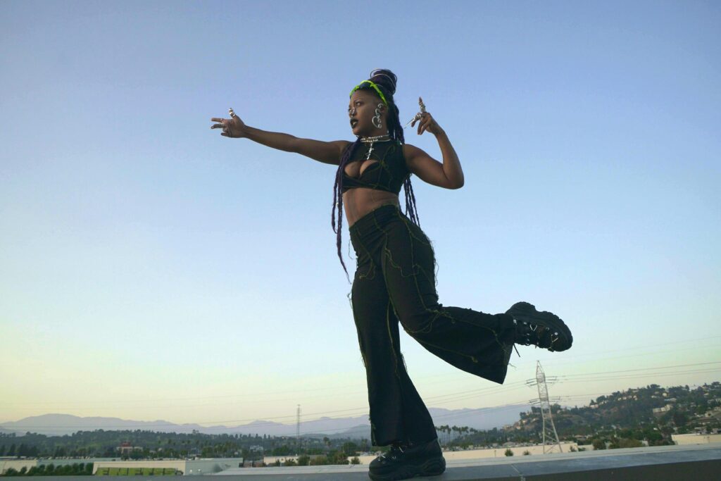 a female dancer wearing black dancing in front of mountains 
