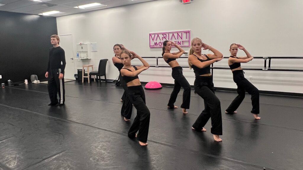 un enseignant regarde 5 danseurs répéter dans un studio