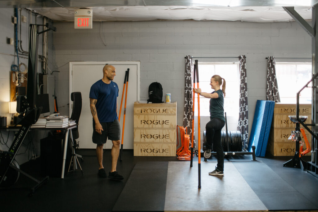 a male trainer working with a female dancer in a garage