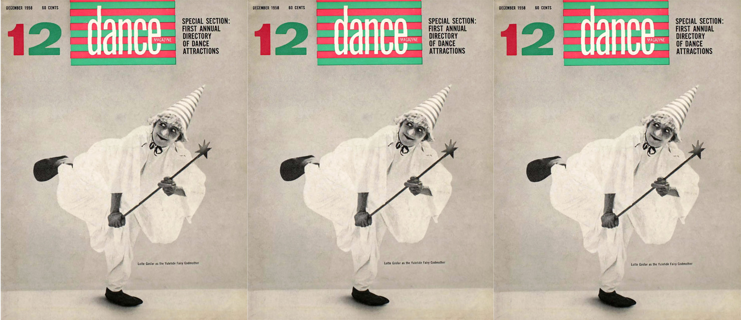 The cover of the December 1958 issue of Dance Magazine. A black and white image of Lotte Goslar shows her dressed in a shapeless white dress, a striped conical hat that ties below her chin, and dark flat shoes. She clutches a star-topped wand in both hands as she balances on one leg, looking over her shoulder as she leans forward and her working leg rises in a low back attitude.