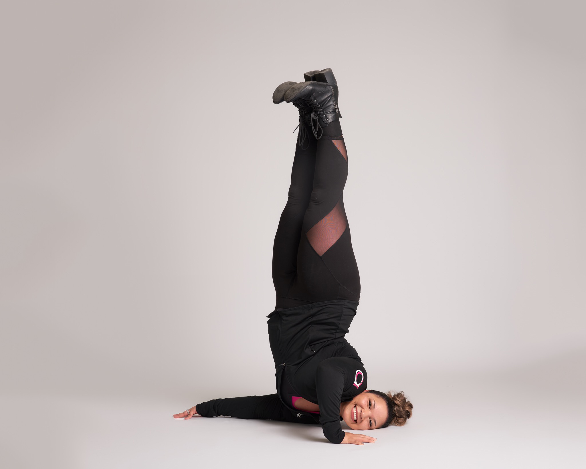 a female dancer wearing black balancing on her shoulder with her legs straight up