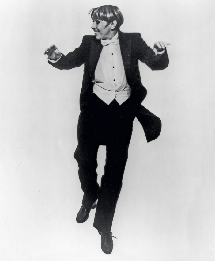 a woman wearing a suit tap dancing 