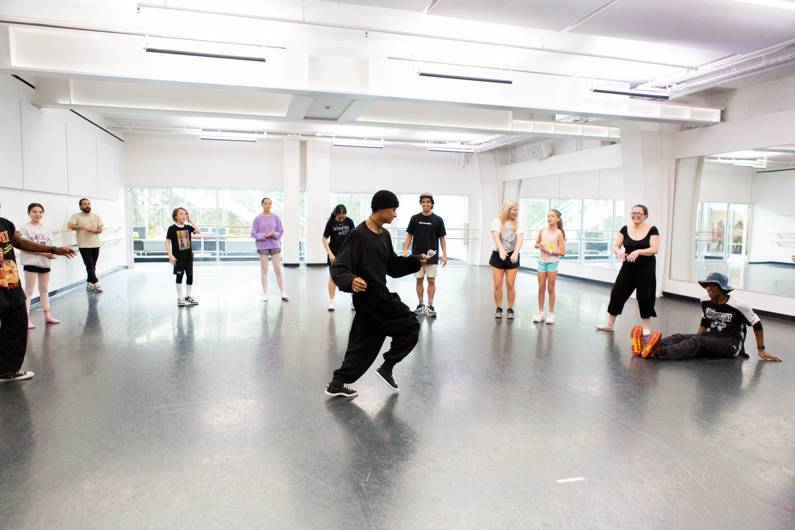 a male instructor teaching hip hop to students in a large studio
