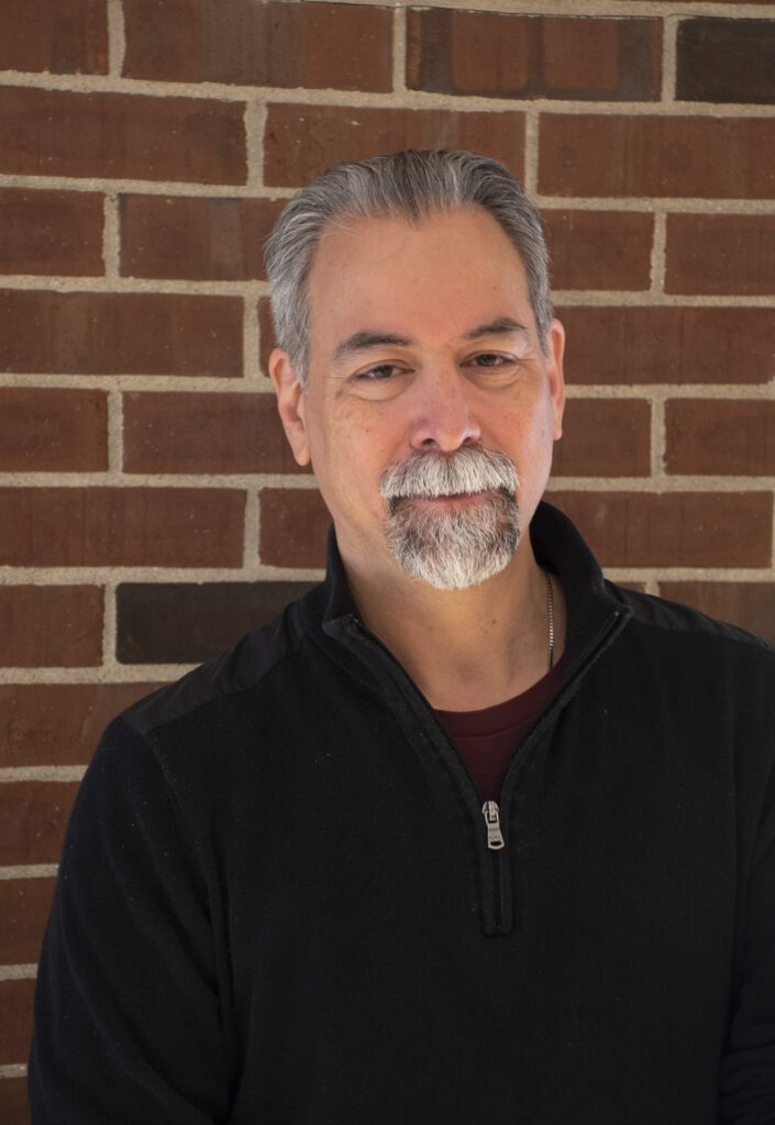 a man with gray hair looking at the camera