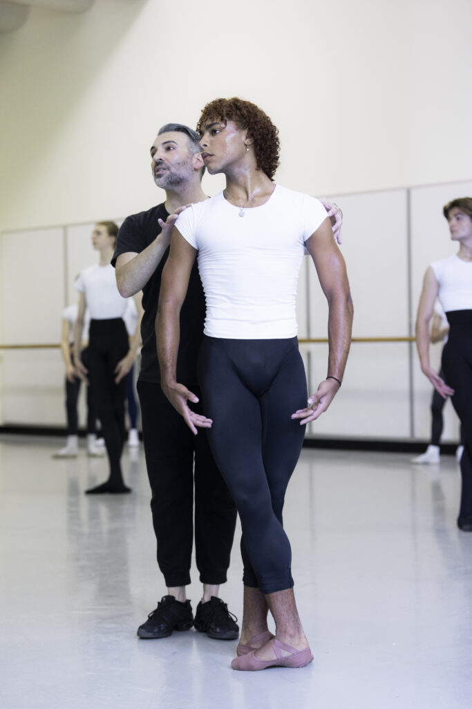 a male dancer being corrected by a male teacher in class