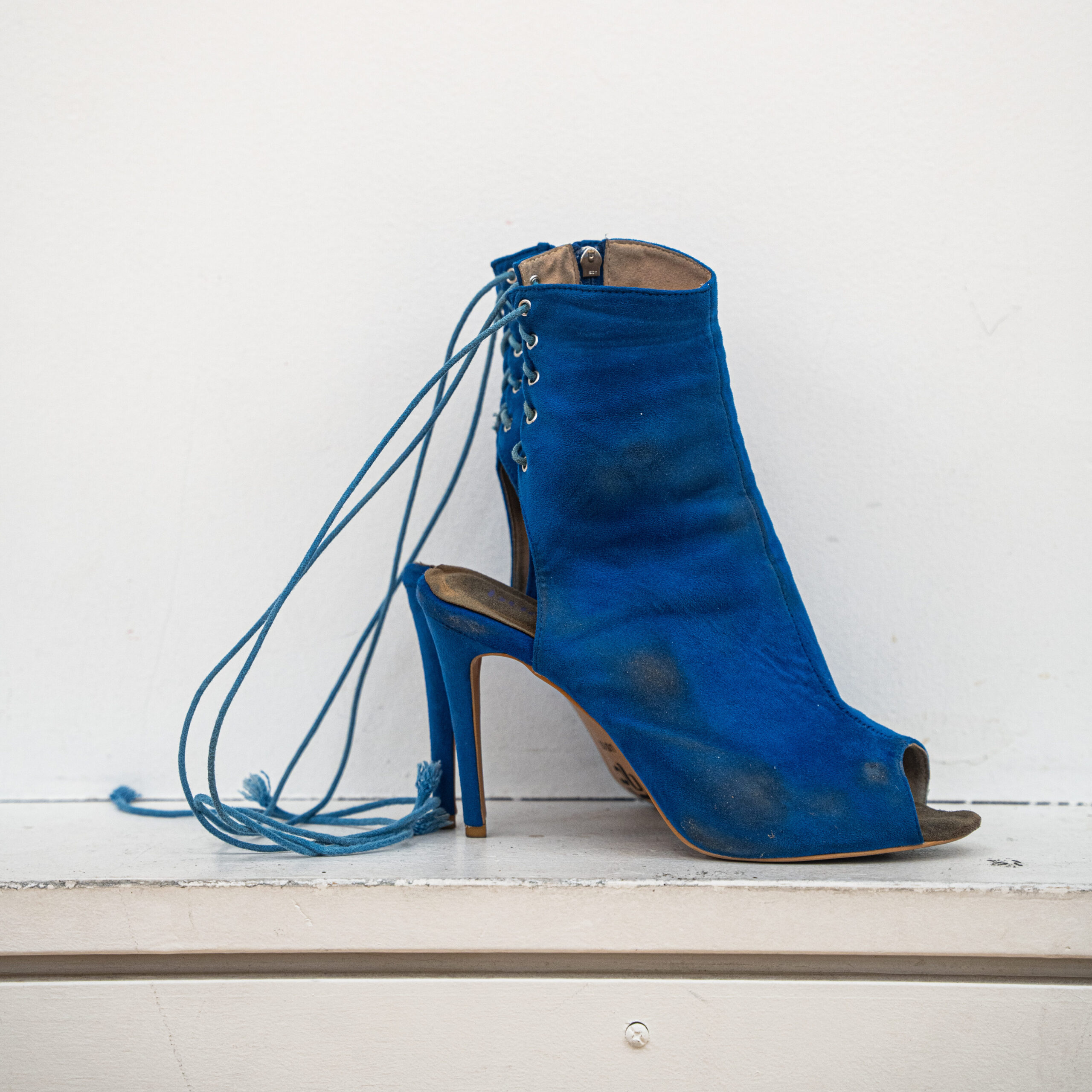 a blue high heel with a lace up back