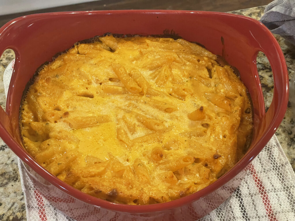 an orange macaroni dish in a large red bowl