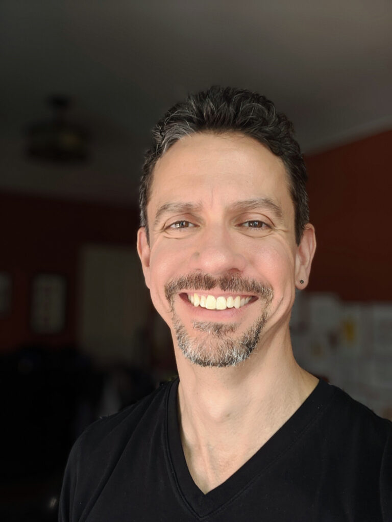 a male with facial hair smiling at the camera