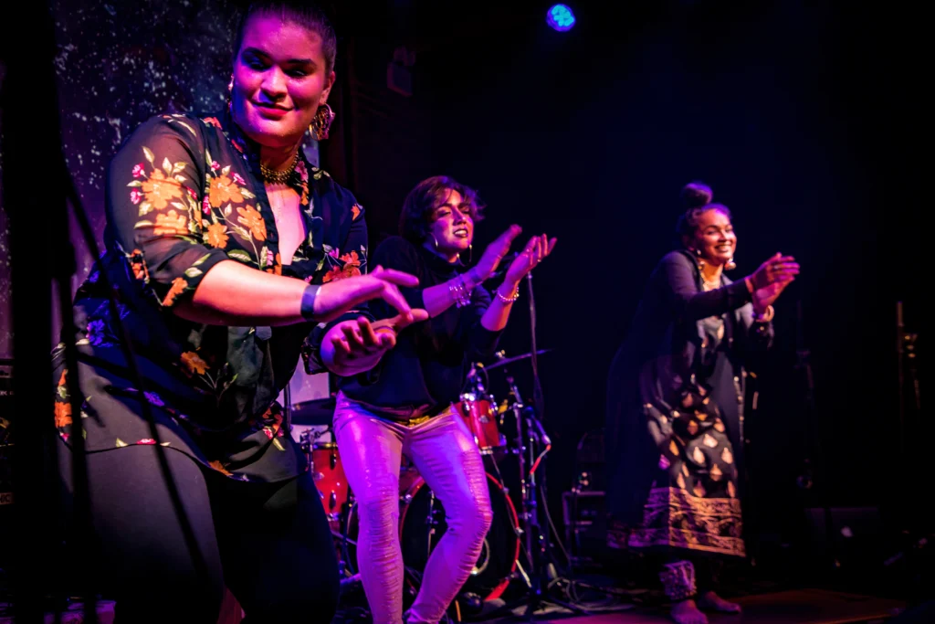 Arielle Rosales, Amanda Castro, and Brinda Guha clap and sway in unison during a Soles of Duende performance.