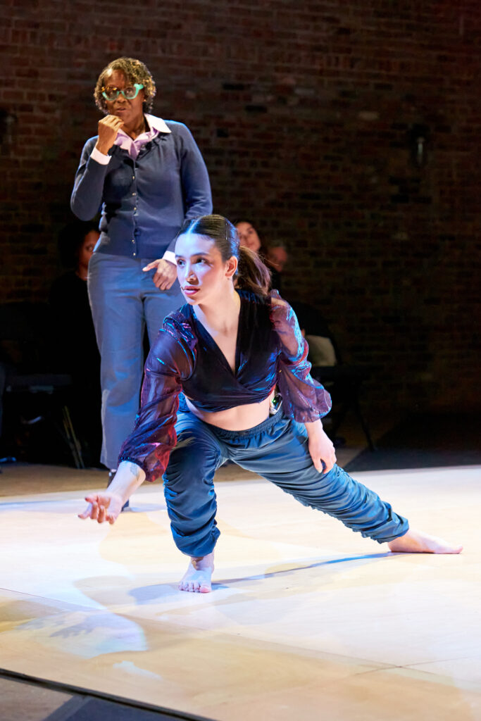 a female dancer lunging to the right with others standing behind her