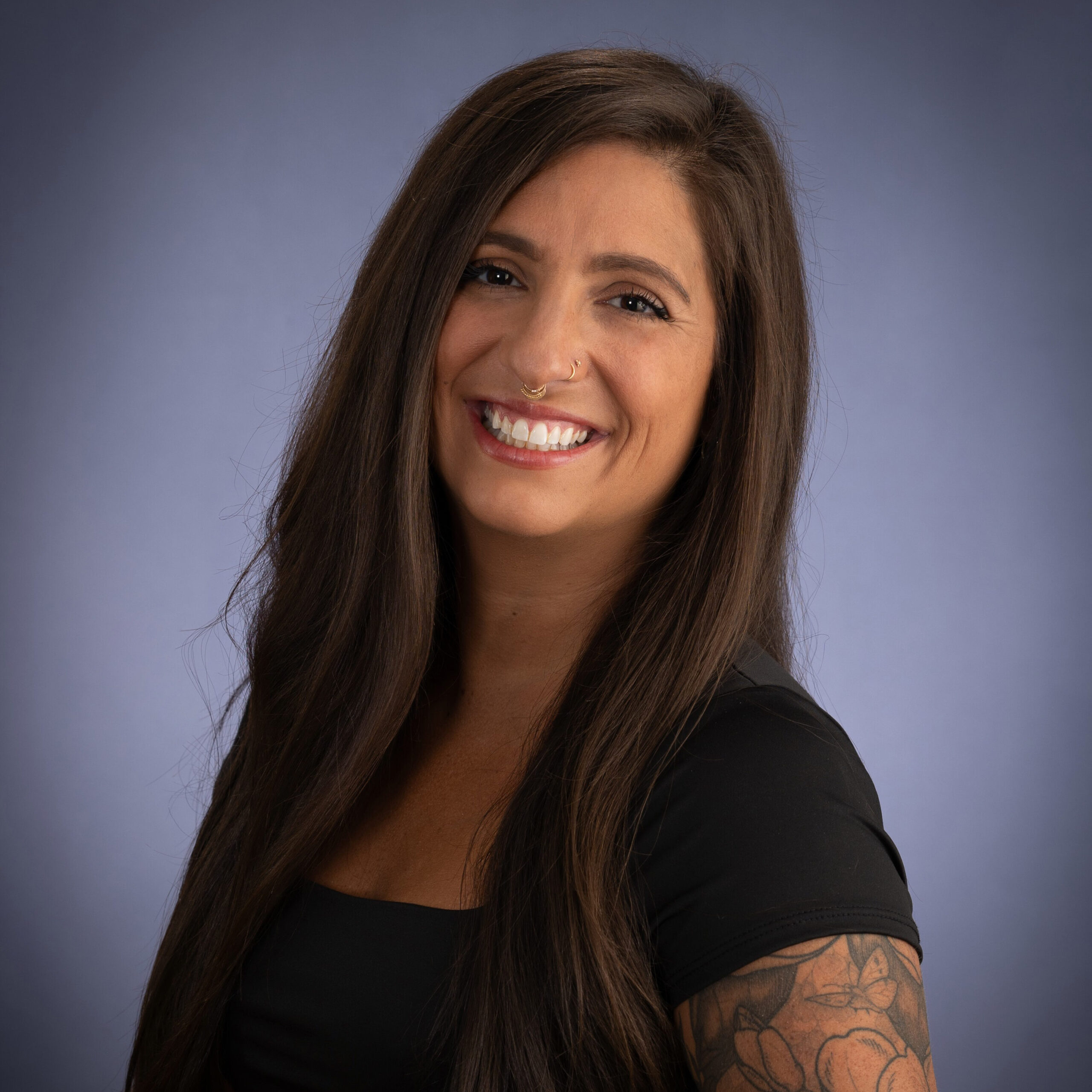 a brunette woman wearing a black shirt smiling at the camera 