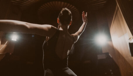 Photo of a ballerina performing on the stage of a theater.