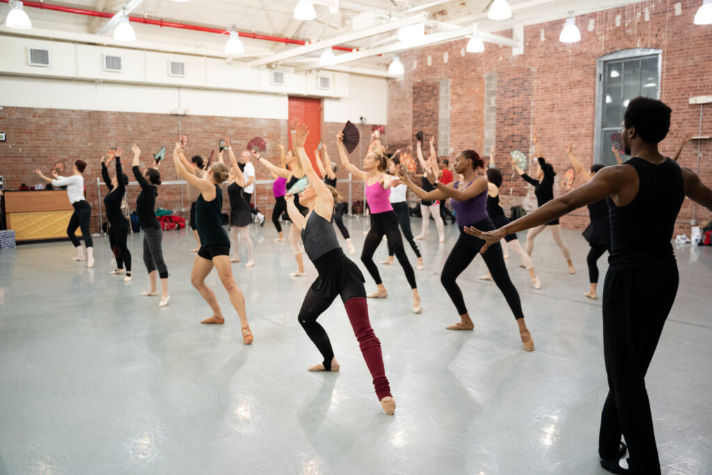a large group of students dancing in a studio