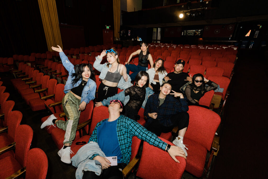 a group of adult dancers sitting in theater seats together
