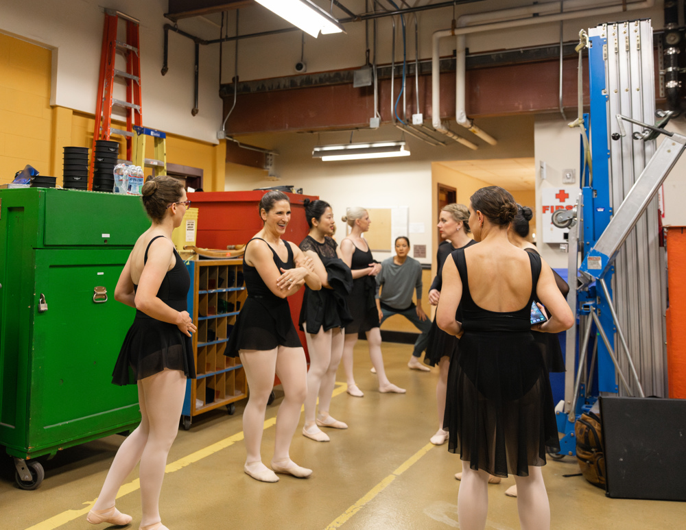 a group of adult female dancers waiting backstage