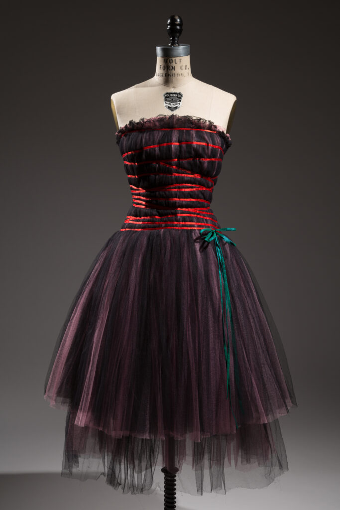a mannequin wearing a red and black knee length tulle dress