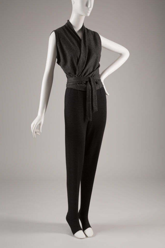 a grey knit wrap top with black leggings on a mannequin 