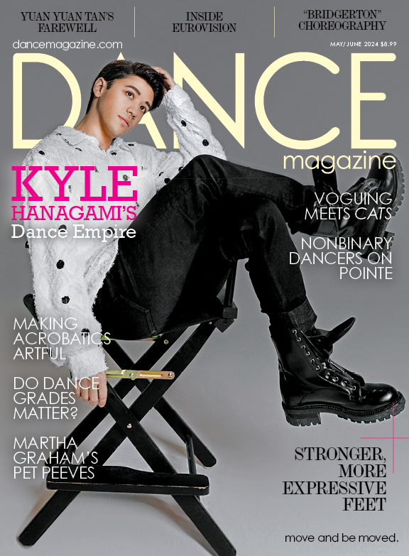 The cover of the May/June 2024 issue of Dance Magazine. Kyle Hanagami sits in a folding chair, legs crossed and dangling over the arm, his head resting in one hand as he gazes up and out. The largest cover line reads, "Kyle Hanagami's Dance Empire." Other text includes "Yuan Yuan Tan's Farewell," "Inside Eurovision," and "Bridgerton Choreography."