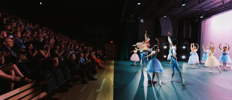 dancers performing in a theater with a packed audience watching from their seats