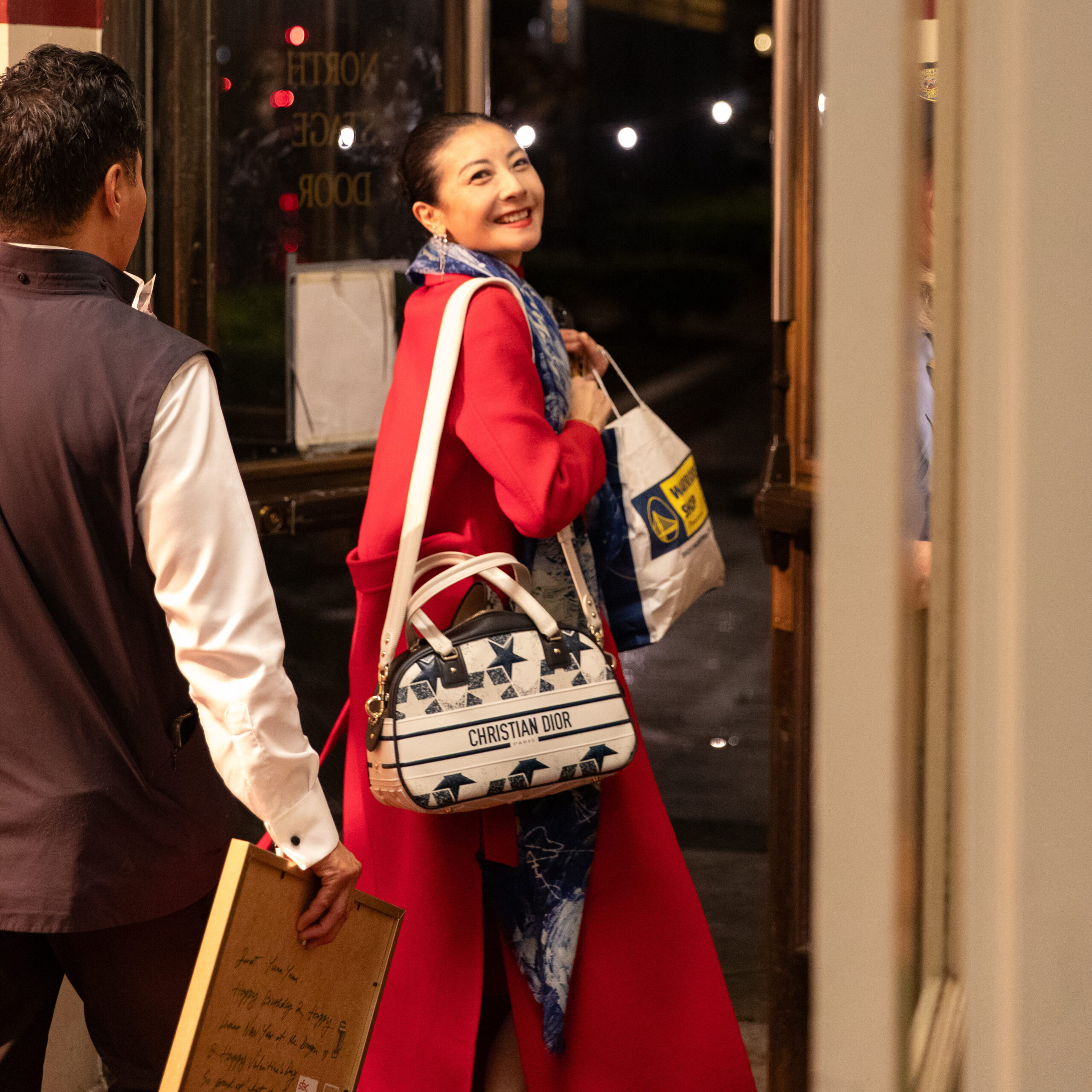 a woman wearing a red coat leaving the theater