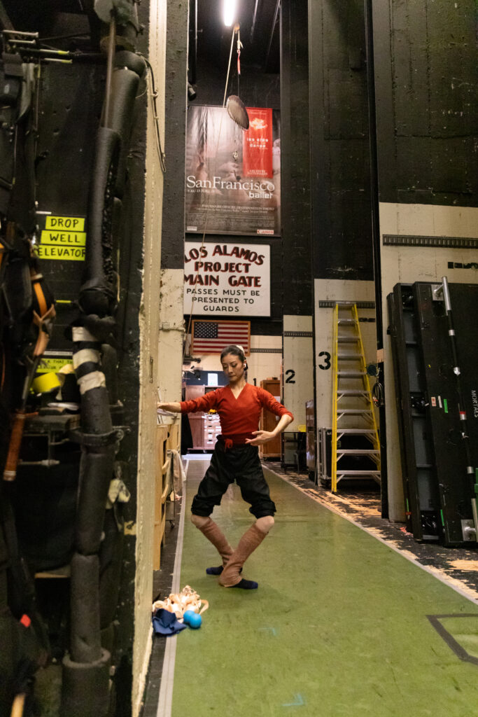 a female dancer warming up backstage 